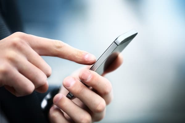 Photo Of A Person Holding And Using A Cell Phone